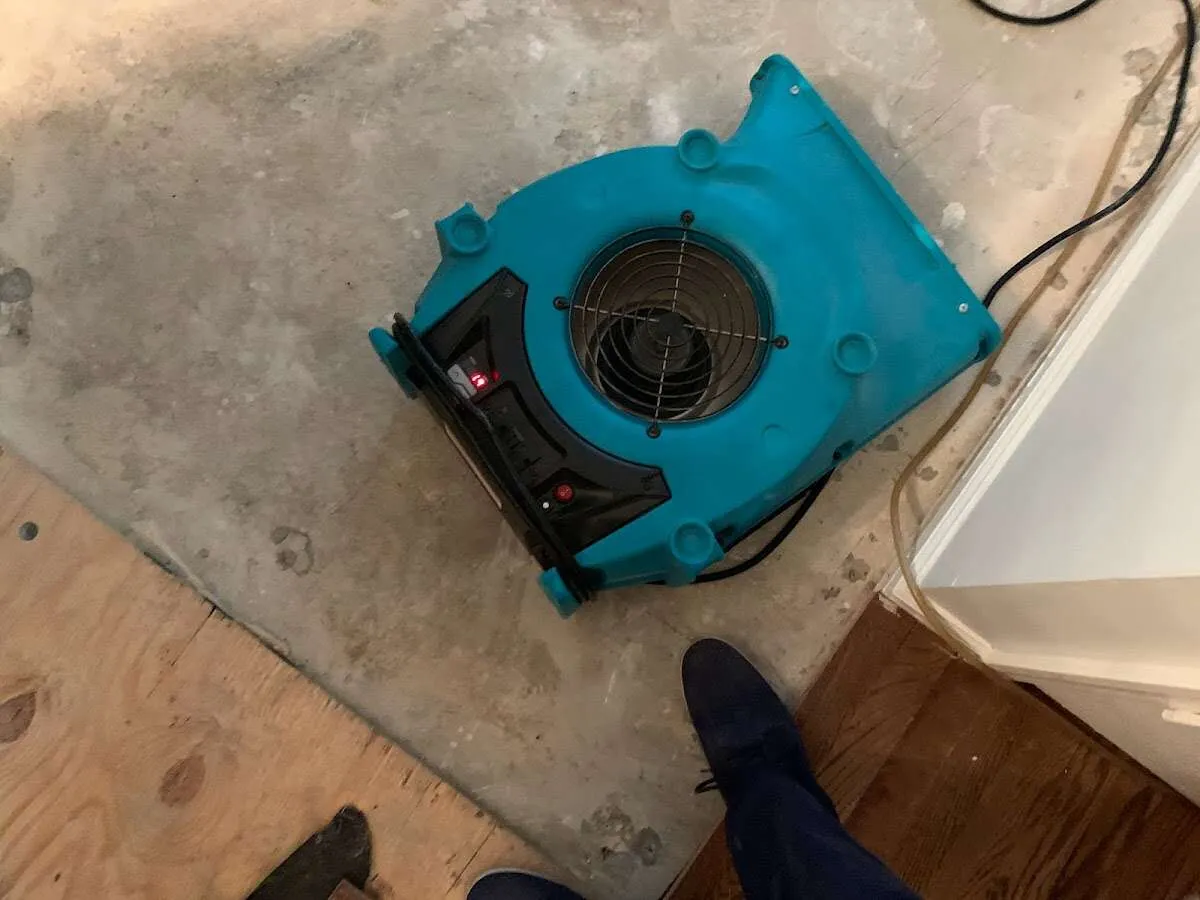 Air mover drying subfloor during Commercial Water Damage Restoration in West Bradford